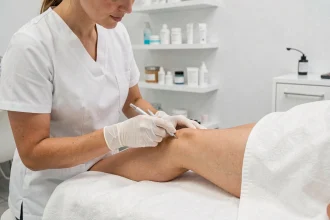 Esthéticienne pratiquant une séance d'électrolyse sur la jambe d'une cliente dans un institut moderne à Montpellier