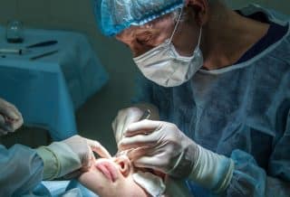 doctor conducting operation at patient in operating room